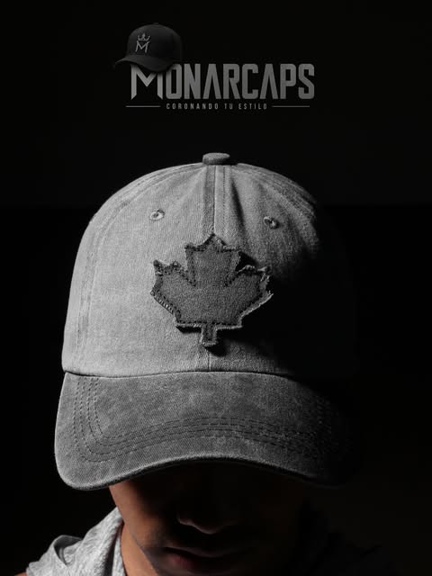 Persona con gorra Monarcaps gris con parche de hoja